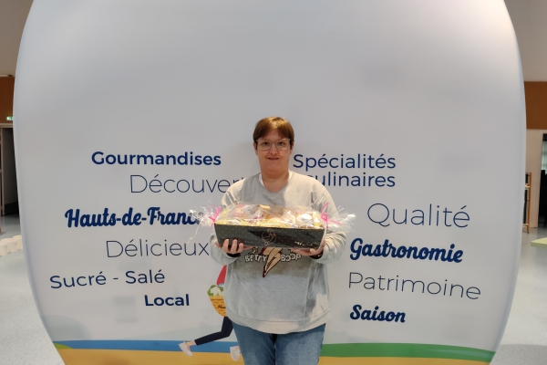Lucile, la gagnante du panier garni mis en jeu dans le cadre de la visite de l'exposition "Délices et Gastronomie en Haut-de-France" à la Médiathèque.